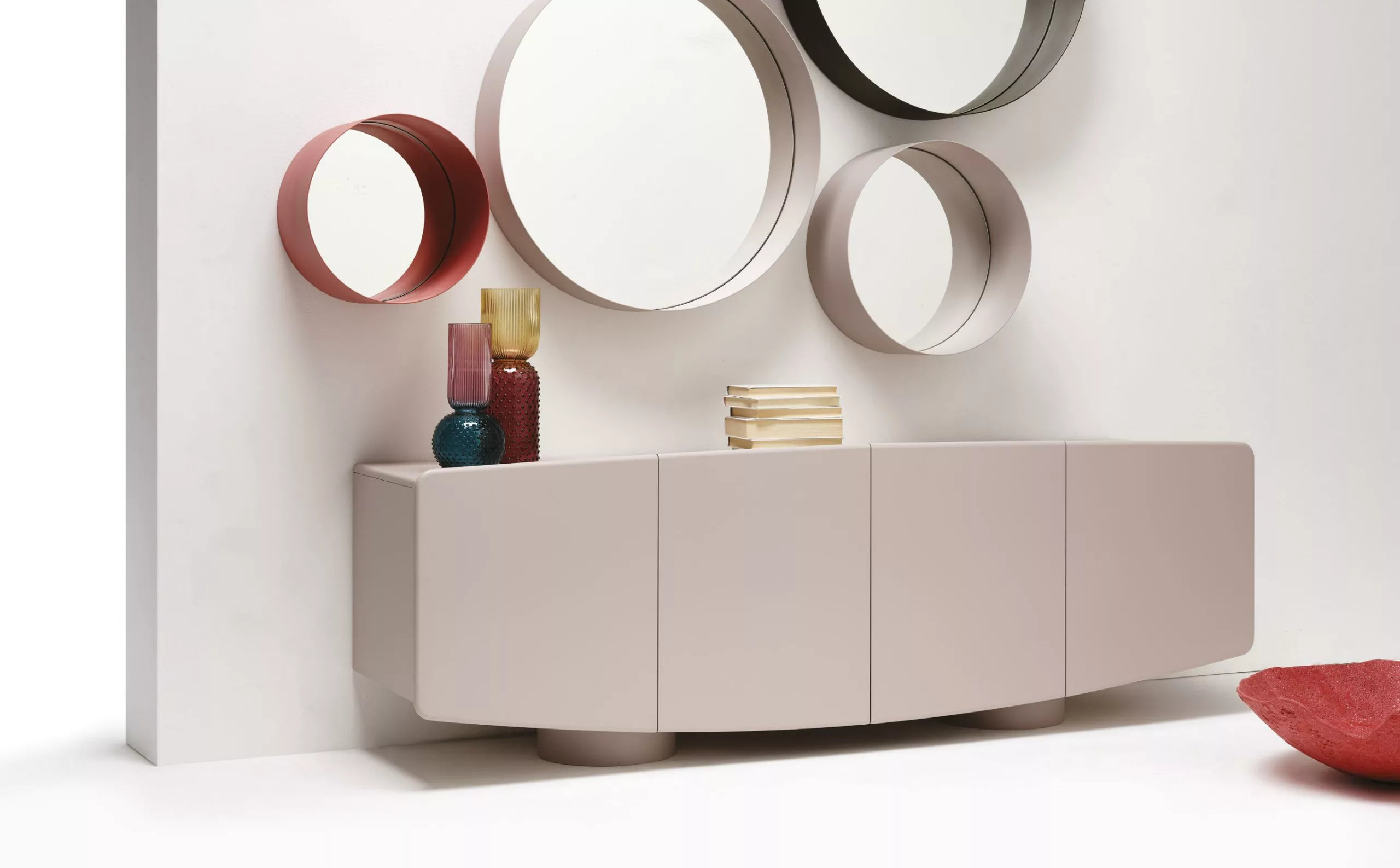 Miroirs ronds de différentes tailles au-dessus d’un meuble de rangement mural Minottiitalia